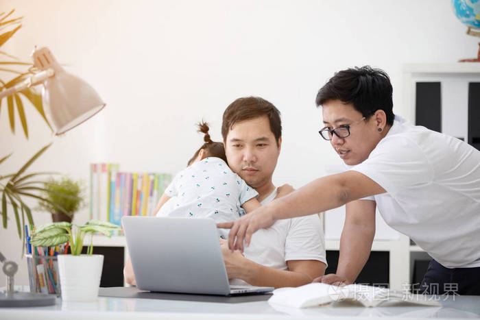 亚洲现代家庭和小女孩, 而爸爸与笔记本电脑工作表在家里办公室