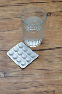 用一杯水和一个水泡包显示白药丸
