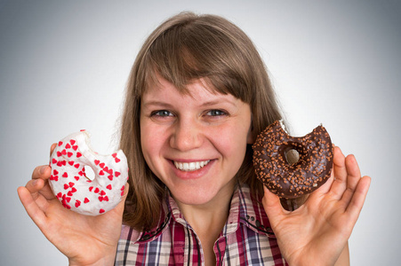 有魅力的女人在两个甜甜圈之间选择