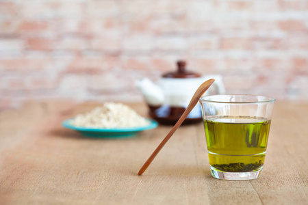 木勺燕麦片用热绿茶放在木头桌上