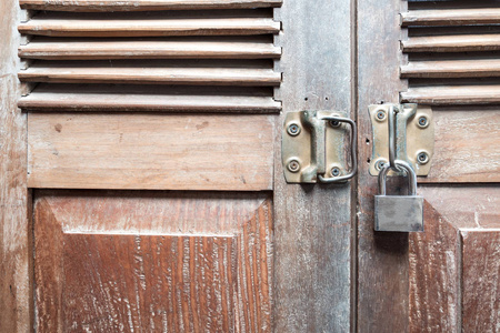 老式木门纹理背景与旧钢锁被锁在闪亮的光与阴影的门。安全差的抽象背景