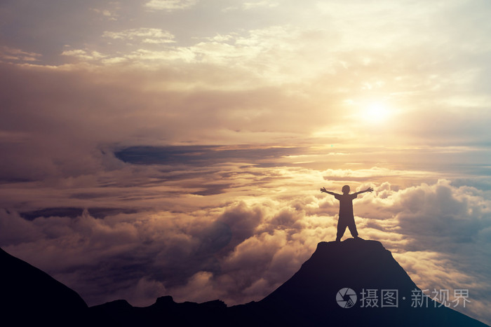 一个男孩站在山顶在云端.succ