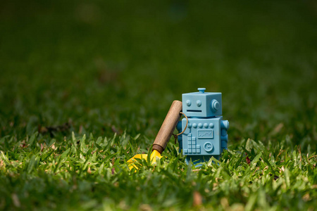 蓝色复古机器人玩具与园林工具在自然绿叶