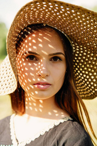 美丽的年轻女子草帽在阳光明媚的夏日在户外