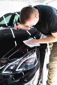 一个男子清洁汽车与超细纤维布, 汽车详细 或 valeting 概念。选择性聚焦