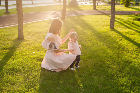 妈妈和小女儿在夏日公园玩着幸福的家庭观念。自然场面与家庭户外生活方式。美容系列