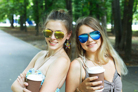 两个漂亮的年轻波西米亚女孩在公园里喝咖啡