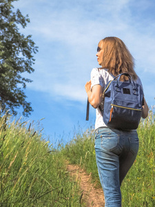 女孩旅行者徒步旅行与背包在高山草甸。旅游生活方式概念冒险暑期户外度假