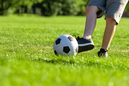 少年前男孩在公园里玩足球