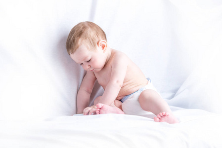 可爱的蓝眼睛的婴儿69 月的微笑和播放白色背景。孩子们的情绪。婴儿的清洁和护理