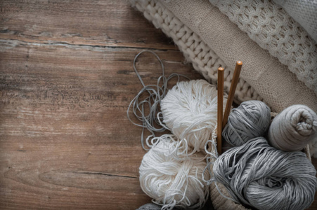 针织和针织针用白色和灰色线编织的篮子。针织特写的白色毛衣和纱线。冬天