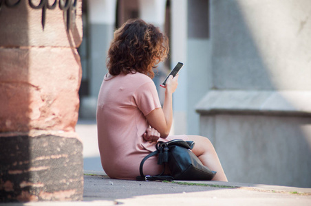 在街上坐着电话的女人的肖像