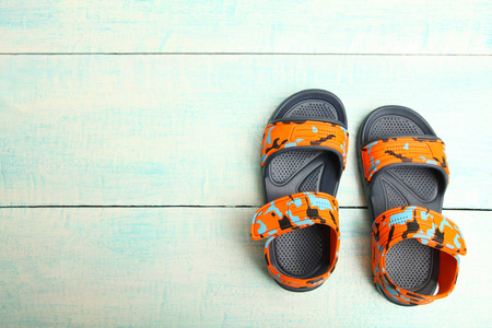 夏日儿童凉鞋上蓝色的木质背景。概念夏日鞋