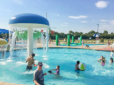 抽象模糊的孩子和他们的父母享受水活动在社区水生中心在得克萨斯, 美国