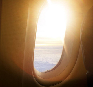 飞机的窗口视图。在日出的窗口飞机与晨光在葡萄酒中的光芒