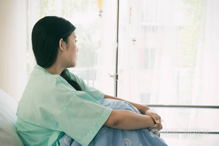 亚洲压力患者妇女看窗外 病人很高兴从疾病中恢复过来.