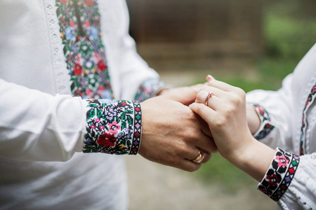 特写新娘和新郎的手与结婚戒指。新娘的手