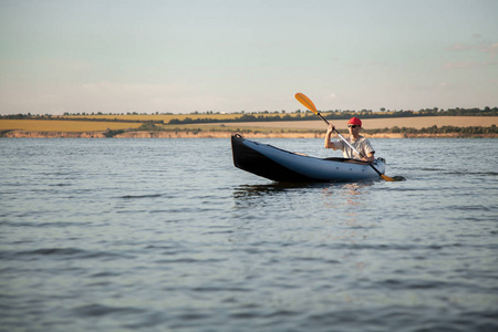 一个年轻人正在乘独木舟。宁静的海水和灿烂的阳光
