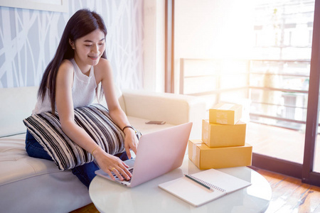 亚洲年轻女子使用笔记本电脑在线检查订购产品。购物在线概念