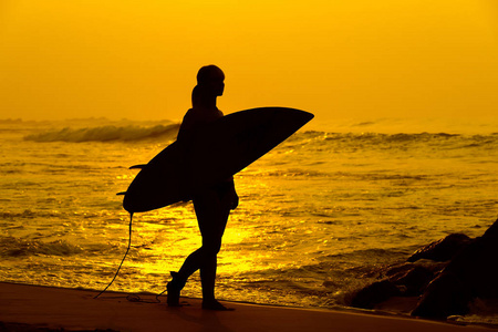 冲浪冲浪女孩看着海洋沙滩日落。剪影 w