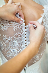扣扣上新娘礼服，细节的美丽的花边婚礼礼服