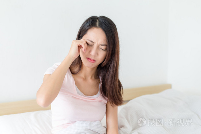 女人的感觉头痛,坐到床上