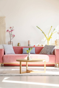 垫子上的红色长椅和木桌在客厅内部与花卉。真实照片