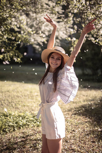 美丽的年轻女子在一个夏日花园, 休闲浪漫的风格与帽子