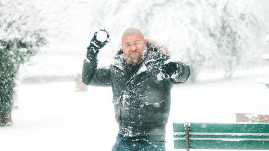 胡子和剃光头的人准备在大降雪期间在公园或森林中投掷雪球冬季 2018 2019