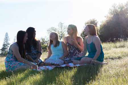 女孩子一起坐在绿草如茵的球场上阳光开销