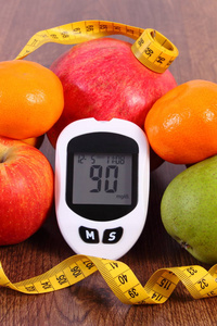 血糖仪与厘米和新鲜水果，糖尿病和健康营养的概念