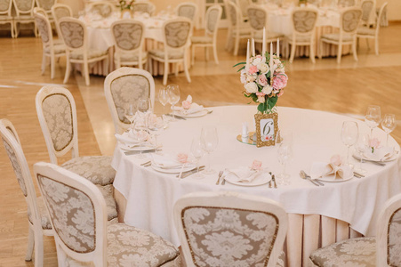 婚礼餐桌装饰的白色和粉红色的玫瑰，康乃馨和蜡烛
