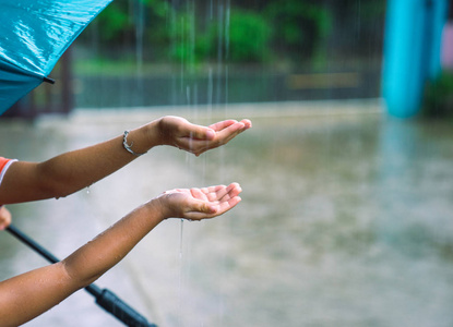 孩子们把手放在雨中捕捉雨滴