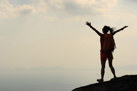 女人张开双臂在山的徒步旅行者