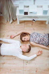 快乐的年轻夫妇，一起躺在地板上