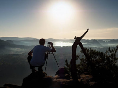 摄影师用相机的岩峰上拍照