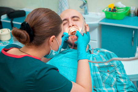 牙医在牙科办公室里插入假牙人