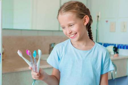 可爱的小女孩在浴室里刷牙。完美的雪白微笑的小女孩
