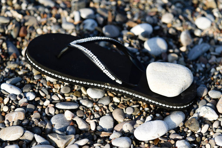 沙滩鹅卵石上的橡胶鞋
