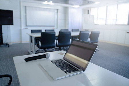 笔记本电脑或笔记本和麦克风放在会议室或研讨会室的桌子上, 复制空间