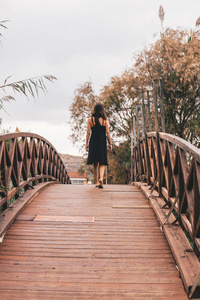 一个女人独自走在一座木桥的顶上