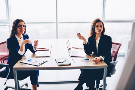 自信的女性财务经理在典雅的正式穿戴创造解决方案一起, 经验丰富的女企业家计划公司预算坐在会议桌上的工作过程