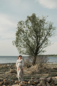 孕妇在岩石湖岸