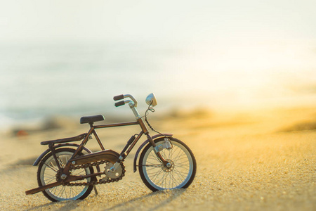 自行车运输玩具在沙滩上海滩在黄昏的天空, 用黄色光束