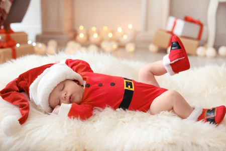 可爱的婴孩在圣诞节服装在毛皮地毯在家