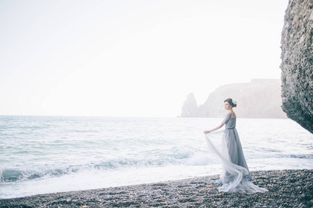 美丽的年轻女子新娘穿着长裙, 靠近海边。婚礼, 幸福, 生活方式概念