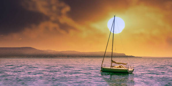 一艘水手小船在日落的湖前与戏剧性的天空