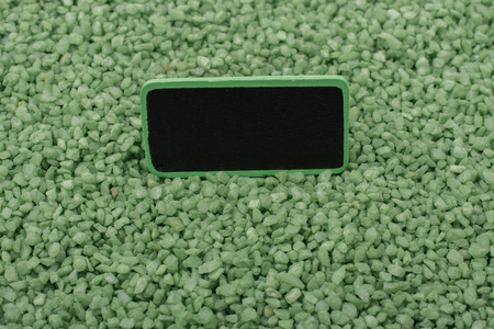 布告栏上框放在绿色的彩色砂上