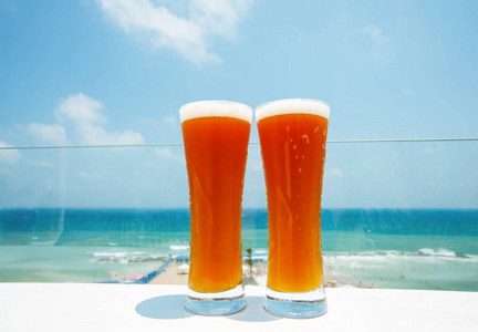 两杯冰啤酒在海上背景下