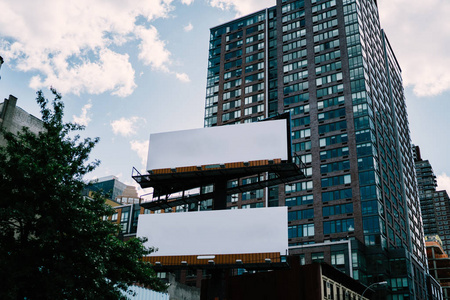 广告或商业信息灯箱在市中心现代建筑外部的宣传模拟区域城市商业区摩天大楼门面上的空白广告牌